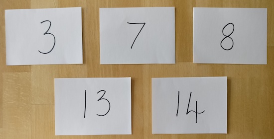 Five envelopes, each with a number written on it. The numbers are 3, 7, 8, 13 and 14