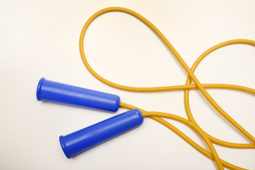 A yellow skipping rope with blue handles.