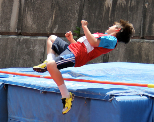A boy doing the high jump.