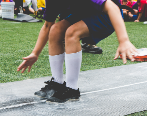 A child doing the long jump at sports day.