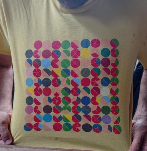 A T-shirt with colourful circles in a ten by ten arrangement.