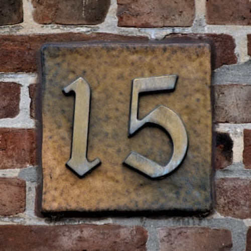The number 15 on a brick wall.