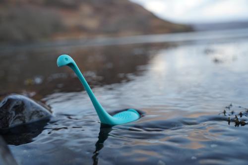 A blue plastic Loch Ness monster toy in a lake.