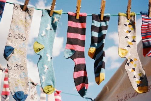 Colourful patterned odd socks on a washing line.