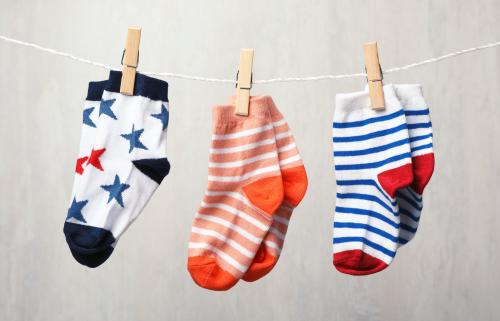 Three pairs of colourful patterned socks on a washing line.