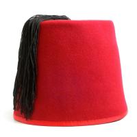 A red fez hat, which is almost cylindrical with tassels on the top.