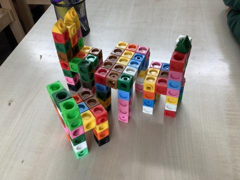 Three chairs and a table made of interlocking cubes