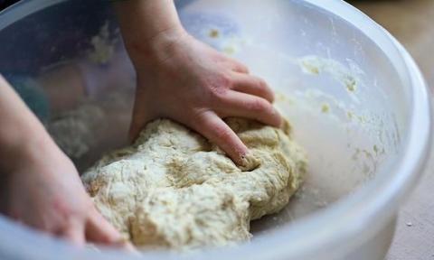 Cooking with Children Some dough is being kneaded in a large cooking bowl.