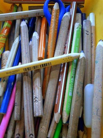 Packing An assortment of coloured pencils, as well as a blue pair of scissors, are packed into a tray.