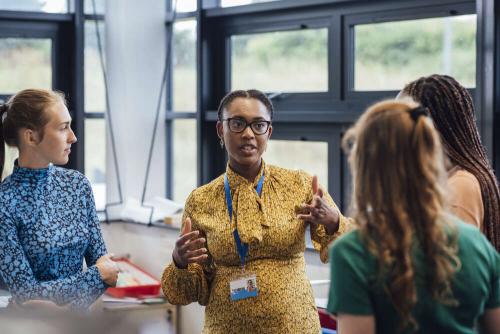 Four professional women wearing different colours in a discussion