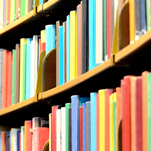 Colourful books on curved library shelves.