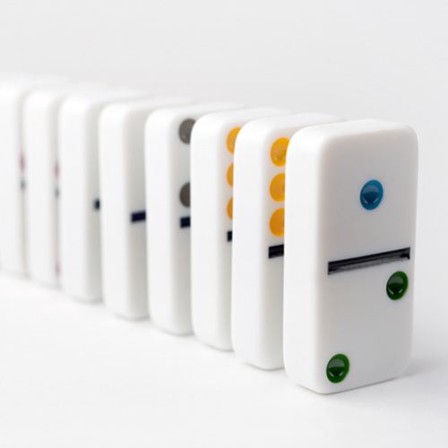 A line of eight dominoes standing on their ends.