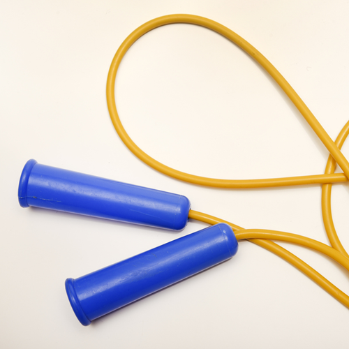 A yellow skipping rope with blue handles.
