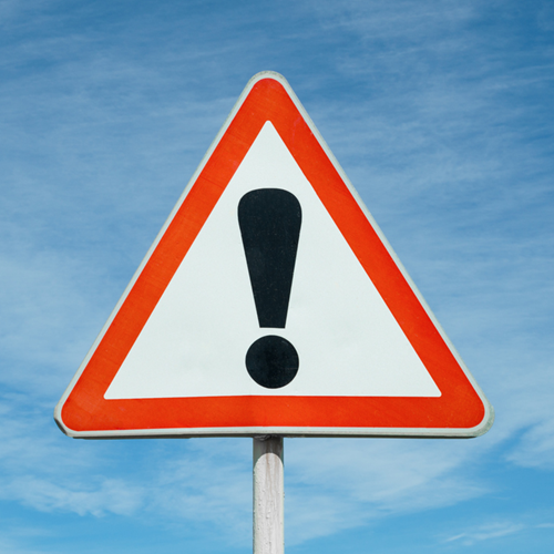 A red warning triangle road sign with an exclamation mark.