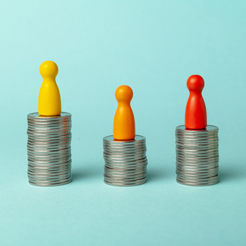 Coloured wooden figures on top of unequal stacks of coins.