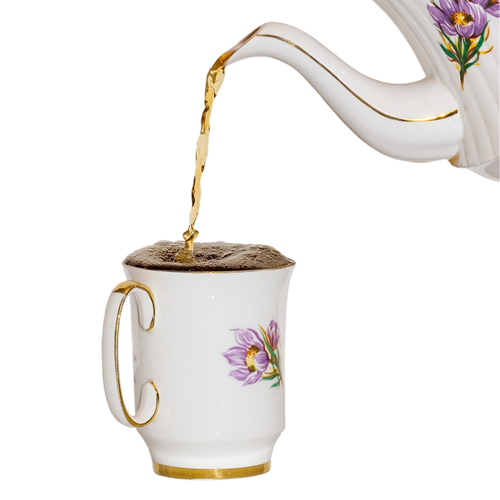 A cup of tea being filled to the brim.