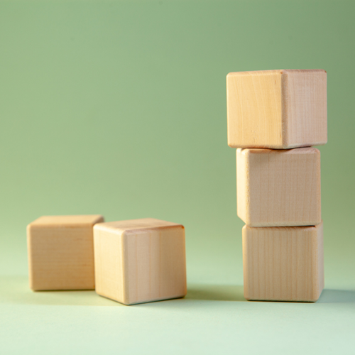 Five wooden cubes with a green background.