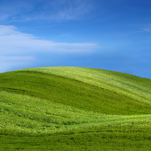 Grass-covered hills beneath a blue sky.