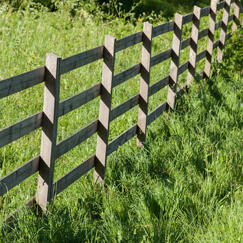 A wooden fence in a field.
