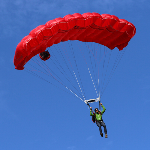A BASE jumper with a red parachute.