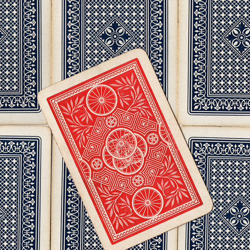 A playing card with a red back, on top of some playing cards with black backs.