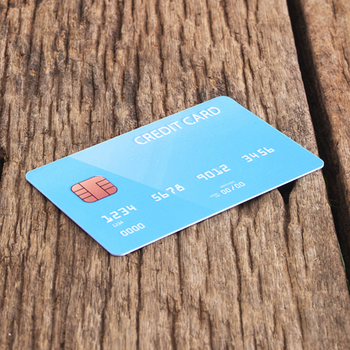 A blue credit card on a wooden table.