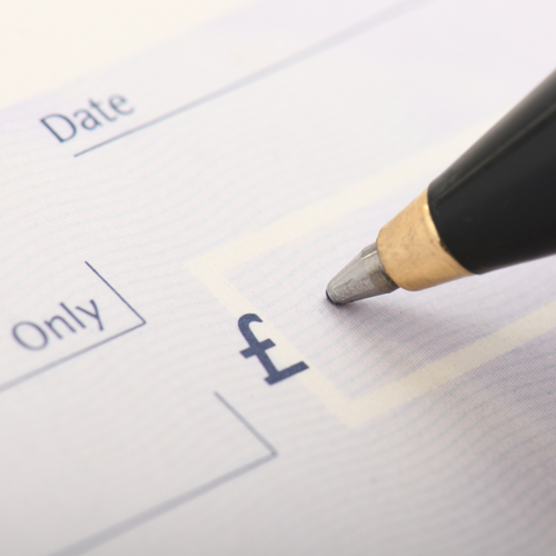 A pen writing an amount of money on a cheque.