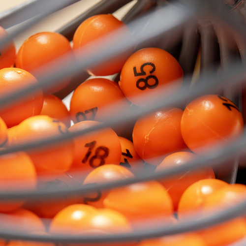 Orange lottery balls in a spinning cage.