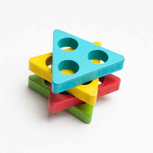 A stack of four coloured wooden triangles.