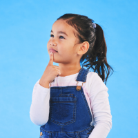 A young girl thinking with one finger on her chin.
