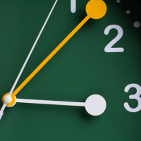 A green clock with yellow and white hands.