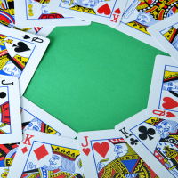 A ring of Jacks, Queens and Kings on a green table.