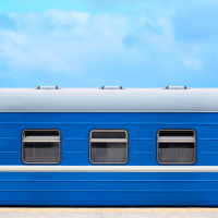 A blue train carriage against a blue sky.