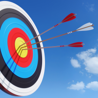 An arrow target with three arrows sticking out of the centre section.