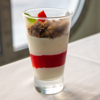 A breakfast parfait with four layers of yoghurt, fruit and granola.